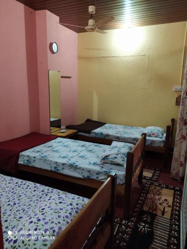 a room with three beds and a ceiling at VANASIRI COTTAGE (Tourist Home) in Dharmastala