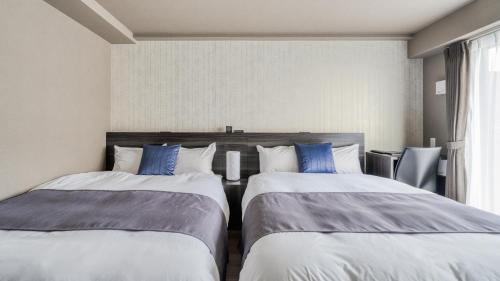 Duas camas sentadas uma ao lado da outra num quarto em BON Condominium Namba Ebisu em Osaka