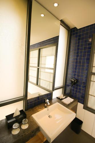 a bathroom with a sink and a mirror at Liberta Hotel Jimbaran in Jimbaran