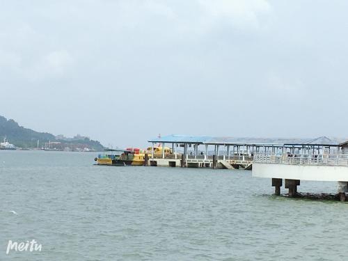 a dock in the water with boats in the water at Dindings Pantai Desair Apartment By DPD in Lumut