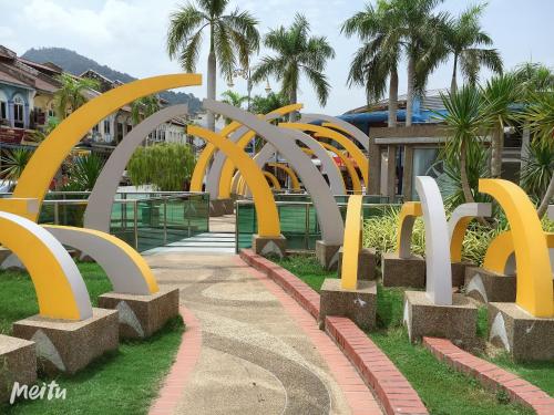 a walkway with yellow and white sculptures in front of a building at Dindings Pantai Desair Apartment By DPD in Lumut