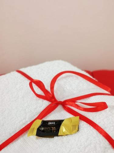 a white towel with a red ribbon and a tag at La Casina di Sant Agostino in Colle Val D'Elsa