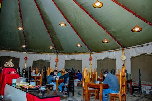 a group of people sitting at tables in a tent at Mara Chui Eco-Resort in Sekenani