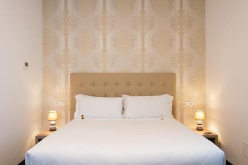 a bed with a white comforter and pillows at Domus Porto Di Traiano Resort in Fiumicino