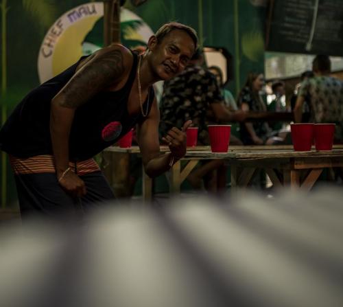 a woman standing at a table with red cups at Chief Mau Moalboal Cebu in Moalboal