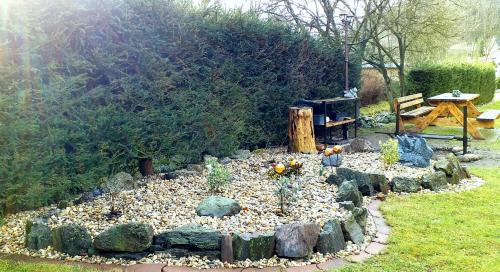 a garden with rocks and a table and a bench at Apartmán Dračí údolí in Trutnov