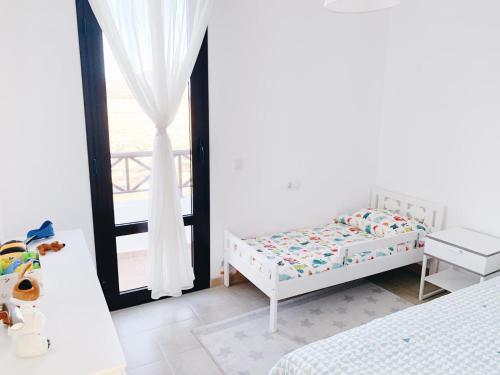 Habitación blanca con cama y ventana en Luxury Villa Lanzarote, en Playa Blanca