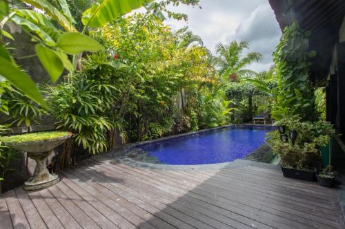 a swimming pool in the middle of a garden at Villa Latebra in Lovina