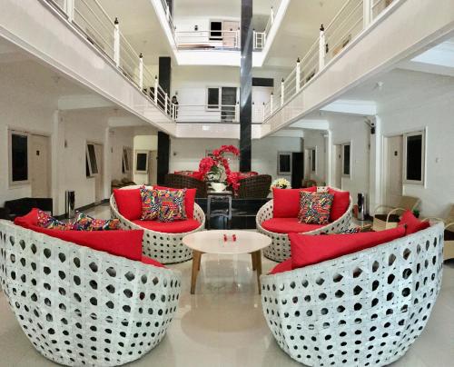 a lobby with red chairs and a table at Gading Guest House in Mataram