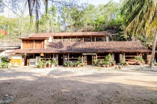an old house with a straw roof at Penginapan Joko Samudro in Baron