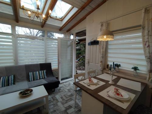 a kitchen with a table and a couch and windows at Mendei Vendégház in Mende