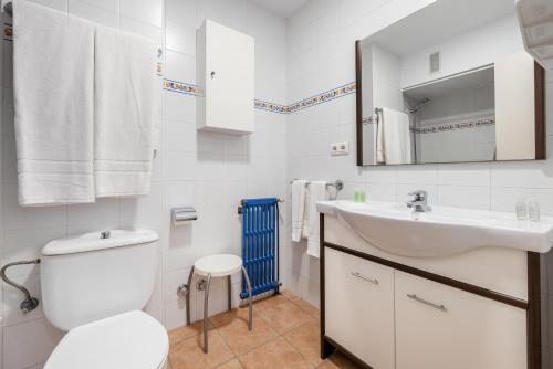 Baño blanco con lavabo y aseo en Apartamentos Astoria, en Tarragona