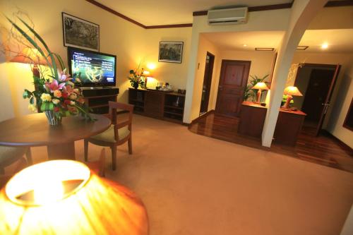 a living room with a table and a television at LAOTEL VIENTIANE in Vientiane