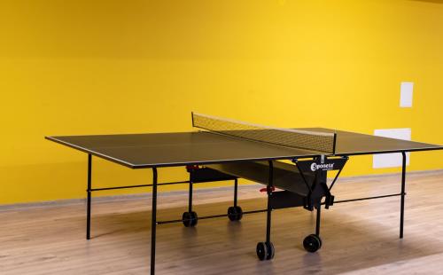 a ping pong table in front of a yellow wall at Thermal Camping Velingrad in Velingrad