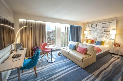 貝濟耶的住宿－貝濟耶美居酒店，酒店客房配有一张床、一张沙发和一张书桌。
