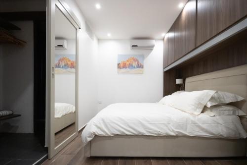 1 dormitorio con 1 cama blanca grande y espejo en Valletta Collection - Zekka Studio, en La Valeta