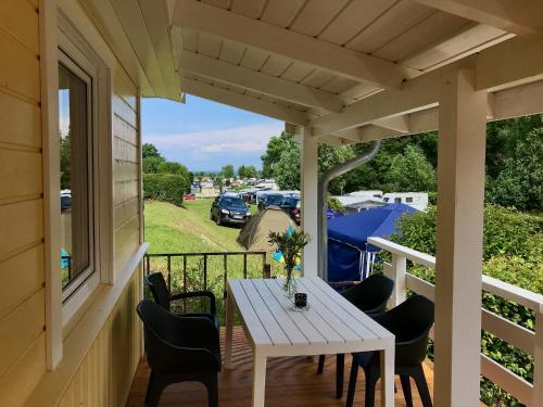 een witte tafel en stoelen op een veranda met uitzicht bij Bungalows Ostseequelle in Hohenkirchen