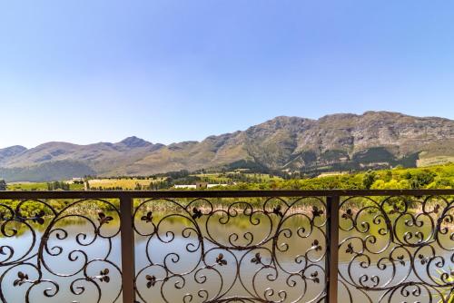 a view from a balcony with mountains in the background at L'ermitage - Franschhoek Chateau & Villas in Franschhoek
