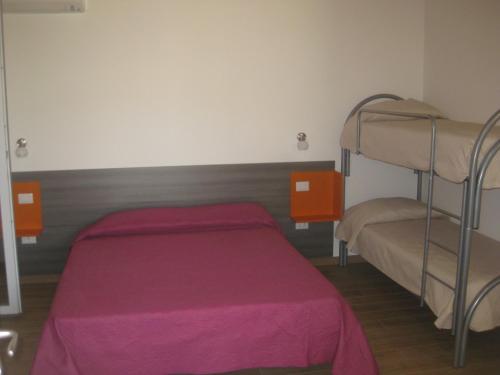 a bedroom with two bunk beds with pink sheets at LE TORRI DEL CILENTO in Santa Maria di Castellabate