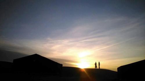 two people standing on top of a hill at sunset at Hostel Amour d'auberge in Marrakech