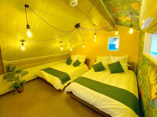 a bedroom with two beds in a tent at 北谷アメリカンヴィレッジまで歩いていける好立地!! サンセットビーチ近くのロフト付ペントハウス in Chatan