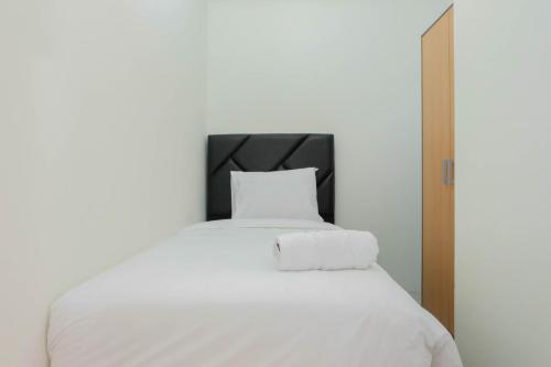 a white bed with two towels on top of it at Exclusive 2BR Bogorienze Resort Bogor near The Jungle By Travelio in Bogor