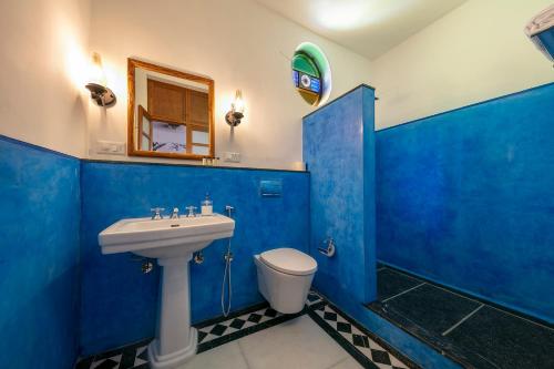 uma casa de banho azul com um lavatório e um WC em Grand Hotel D'Europe em Pondicherry