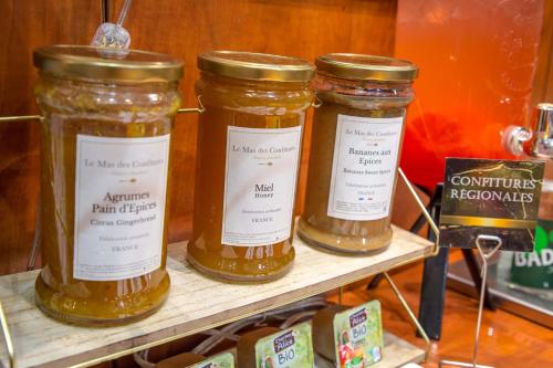 three jars of honey sitting on a shelf at Mercure Béziers in Béziers