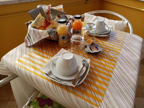 a table with a teapot and cups and plates on it at B&B La Cupella in Monterotondo