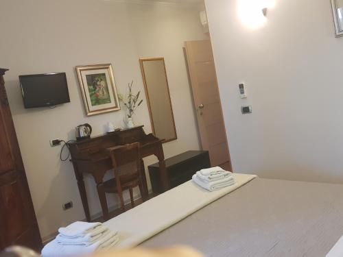 a room with a bed and a desk and a mirror at Aurelia Garden Gold B&B in Rome