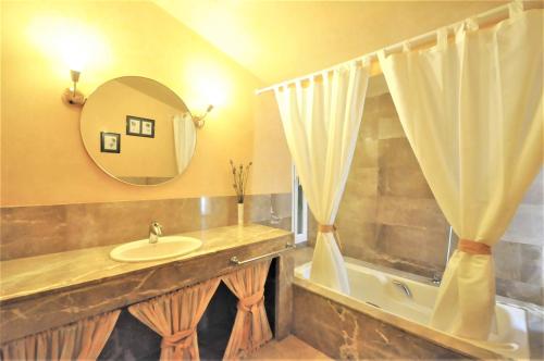 a bathroom with a sink and a tub and a mirror at SA ROTA Finca en Bunyola 8 personas- Muy tranquilo in Bunyola