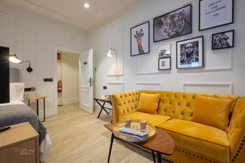 sala de estar con sofá amarillo y cama en Barbarossa Suites Plaza de España en Merida