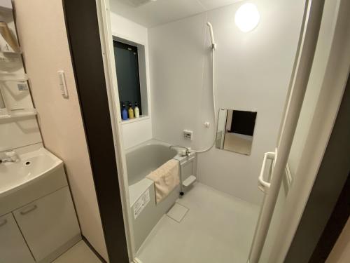 a white bathroom with a sink and a shower at KYOTO STATION HOUSE in Kyoto