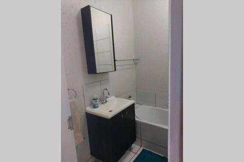 a white bathroom with a sink and a mirror at Ideal Traveller's apartment in Johannesburg