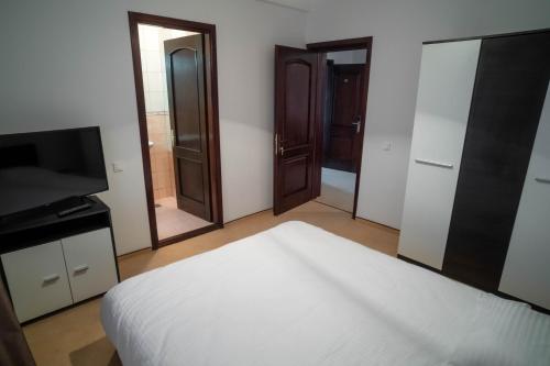 a bedroom with a bed and a tv and mirror at Chalet 173 in Gura Humorului