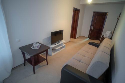 a living room with a couch and a table at Chalet 173 in Gura Humorului