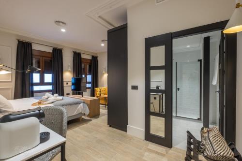 Pokój hotelowy z łóżkiem i lustrem w obiekcie Barbarossa Suites Plaza de España w Meridzie