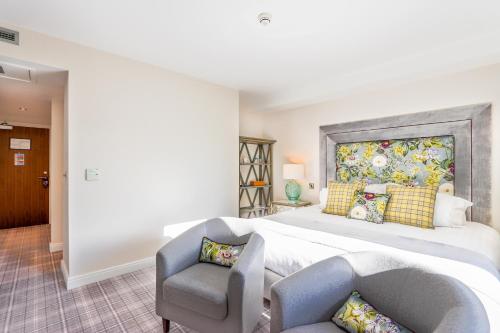 a bedroom with a large bed and a chair at Peak Edge Hotel in Chesterfield