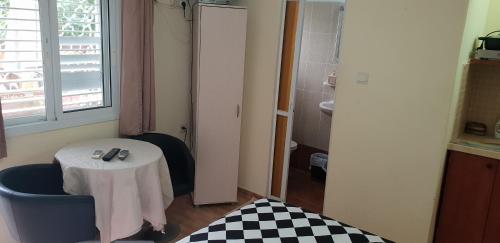 a room with a table and a small table and a window at Naama rooms for rent in Neve Zohar