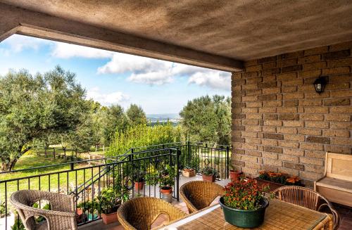 a balcony with a table and chairs and a large window at Poggio della Stella in Blera