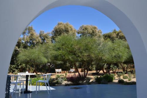 a view of a park with tables and chairs and trees at Crystal Mare Suites in Naxos Chora