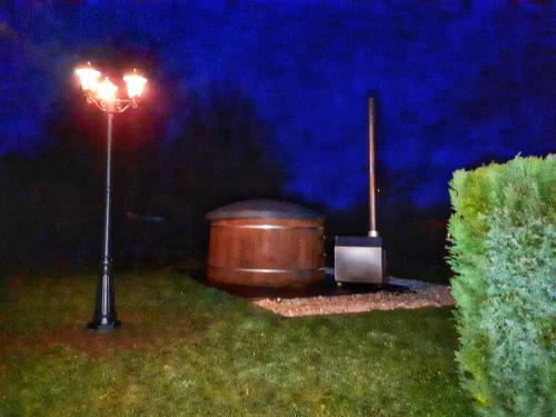 a street light and a barrel in a yard at night at The BlackSmith's House in Libin