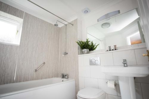a white bathroom with a toilet and a sink at Flackley Ash Country House Hotel in Rye