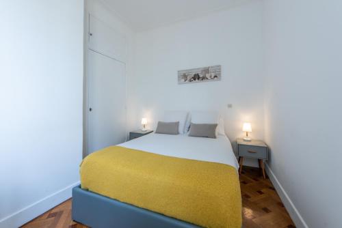 a bedroom with a bed with a yellow blanket at La Suite 111 in Nice