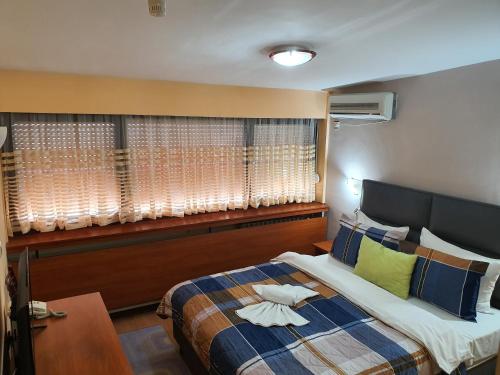 Un dormitorio con una cama grande y una ventana en Hotel Square, en Skopje