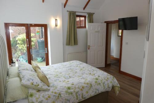 a bedroom with a bed and a door with a window at West View Farm in Louth