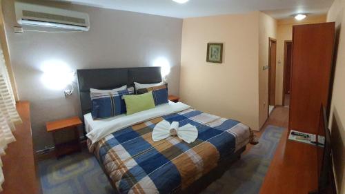 Un dormitorio con una cama con una flor blanca. en Hotel Square, en Skopje
