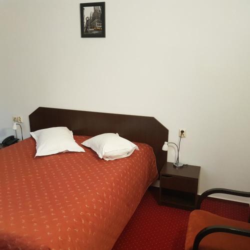 a bedroom with a bed with two pillows on it at Cristal Sinaia in Sinaia