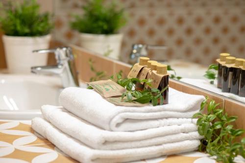 a pile of towels on a sink in a bathroom at ARENDA Villa Amelie en Pino Alto in Miami Platja