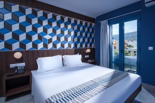 une chambre avec un grand lit et une fenêtre dans l'établissement Compass beach, à Stalida